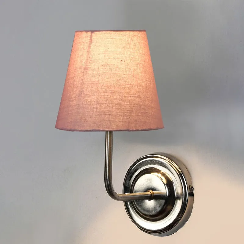 Close view of lit dusty pink wall lamp with steel mount