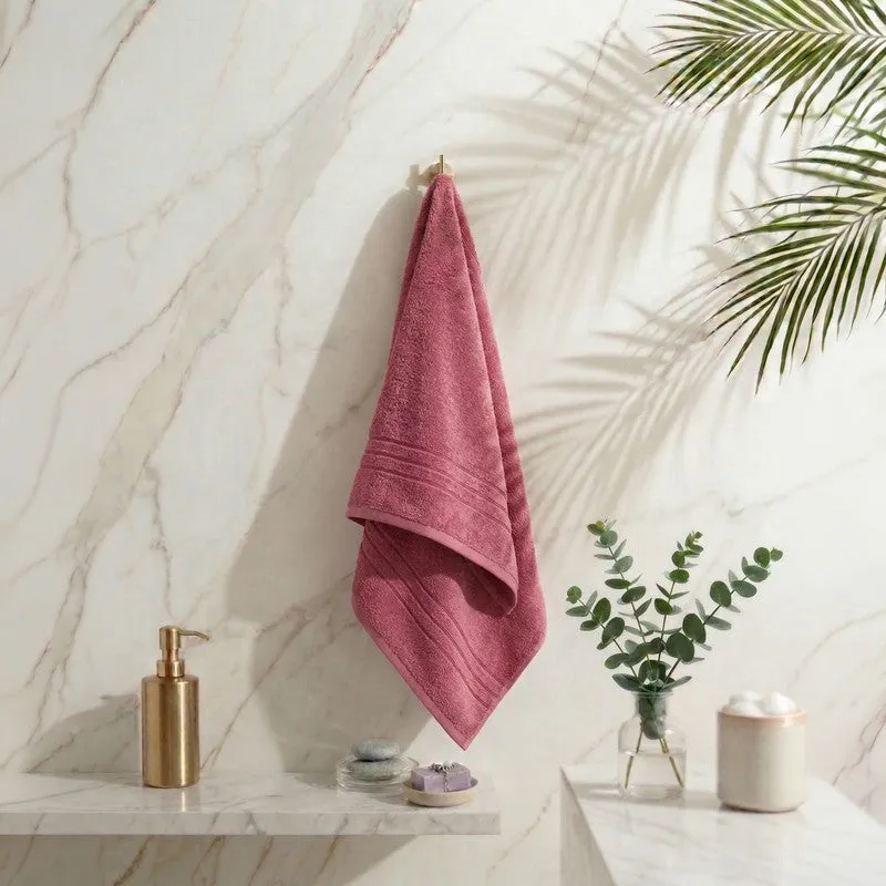 Dusty pink bath towel hanging in a bathroom setting