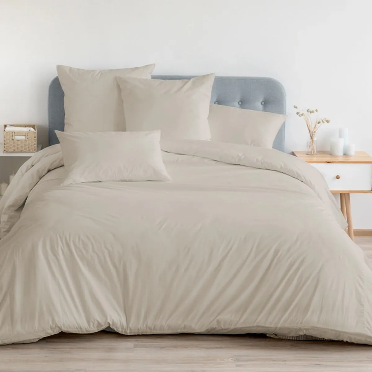 Beige bedsheet spread across a bed with matching pillows