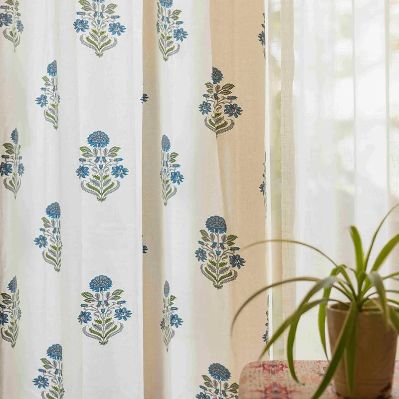Blue floral liberty curtain set of two hanging at a window