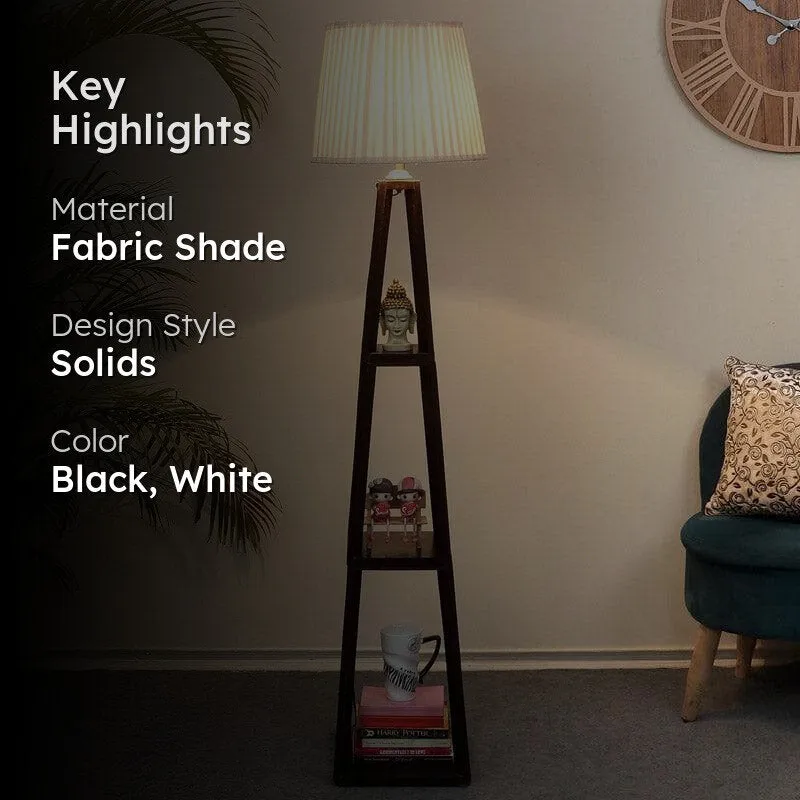 Floor lamp with white shade and black shelf base in a room setting