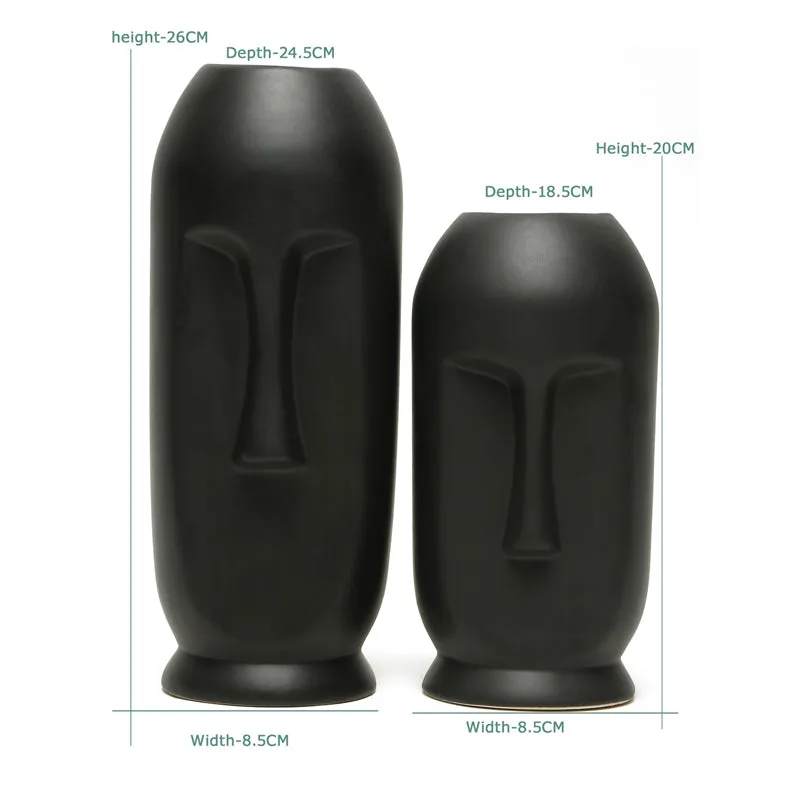 Two matte black face vases on a white background with visible size markings.