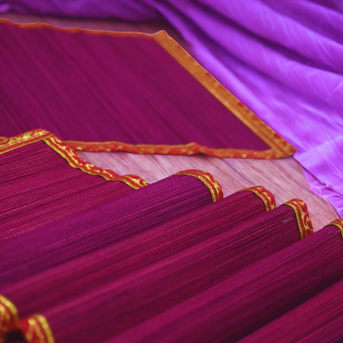 Close-up of pink textured table mat with decorative zari edging
