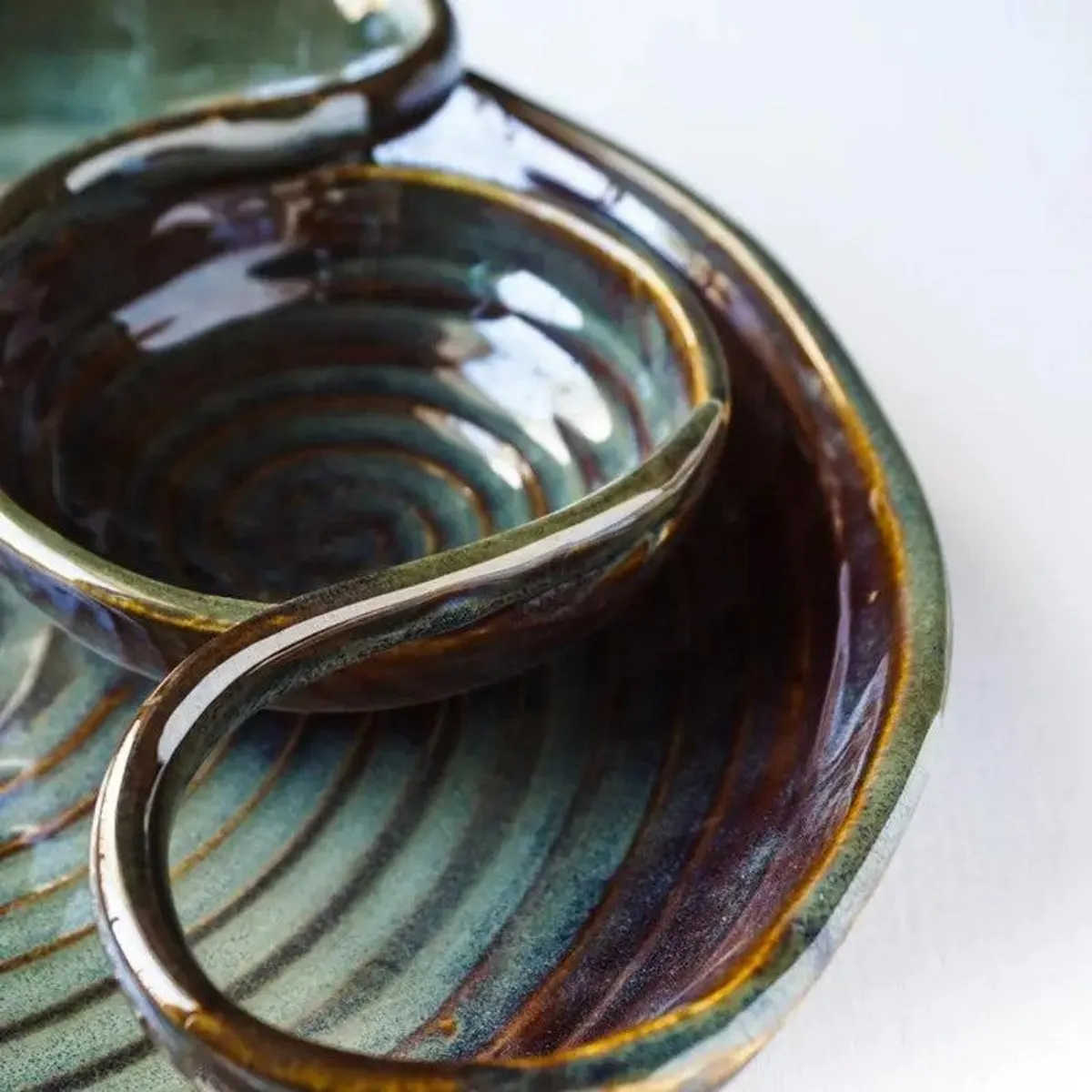 Close-up of the platter's glossy concentric ceramic surface and curved dip section
