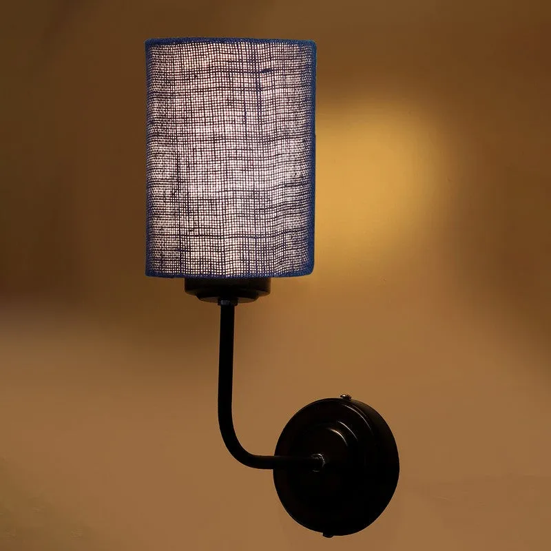 Blue jute wall lamp with black iron wall mount against a warm wall