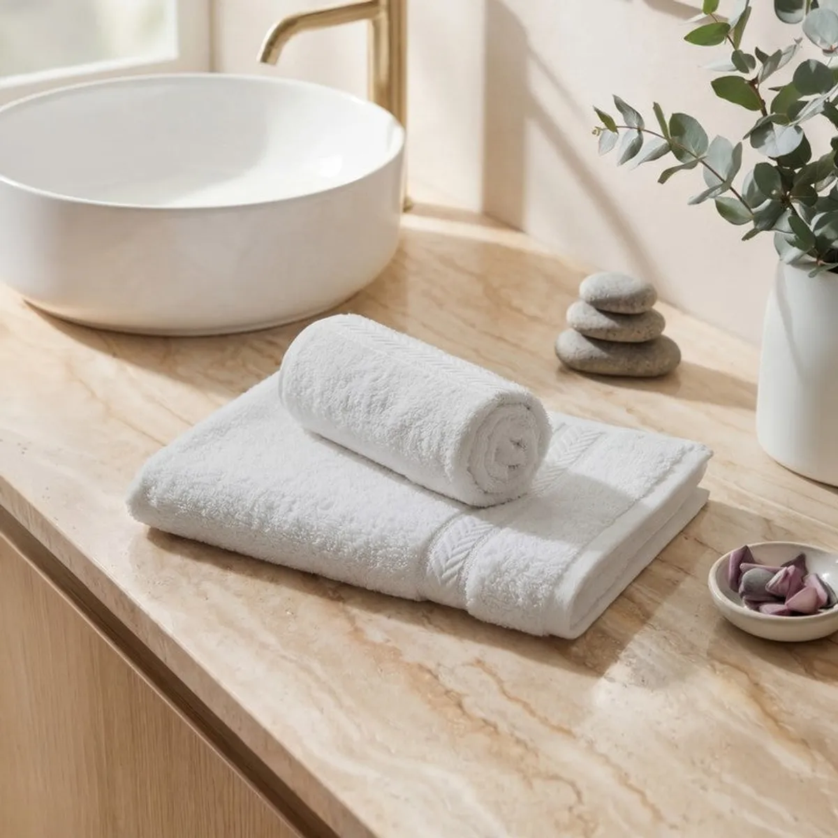 Folded white towels arranged on a wooden bathroom counter