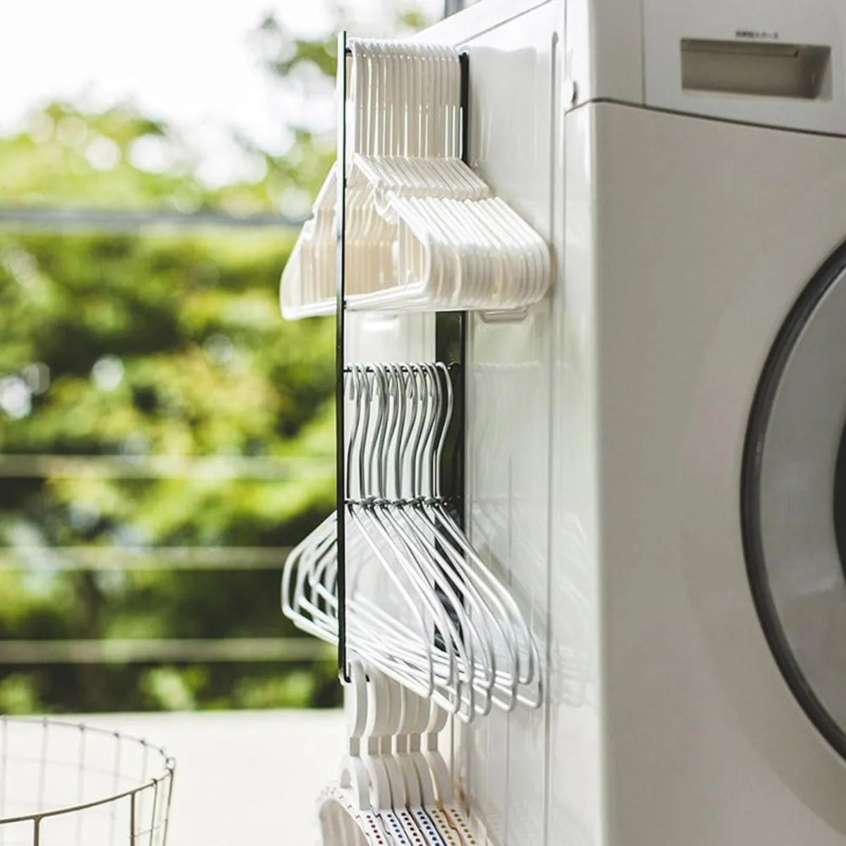 Side view of black magnetic hanger organiser attached to a washing machine