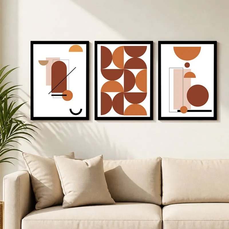 Set of three abstract geometric framed prints displayed above a beige sofa