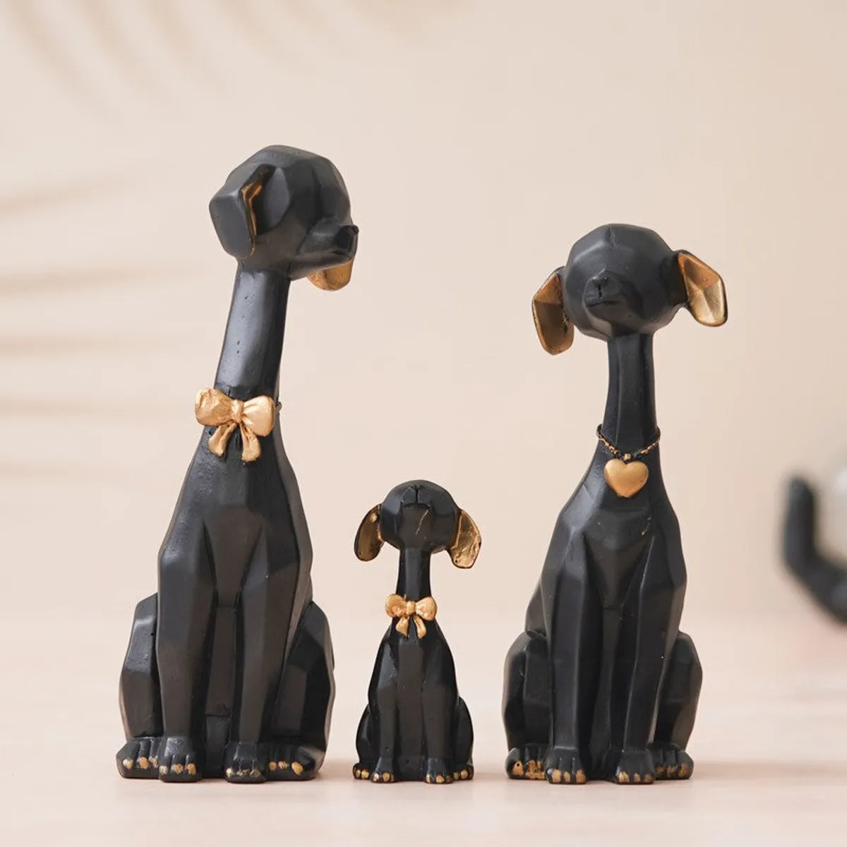 Front view of three black and gold dog figurines