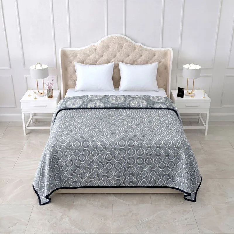 Blue reversible dohar on a bed showing geometric print side