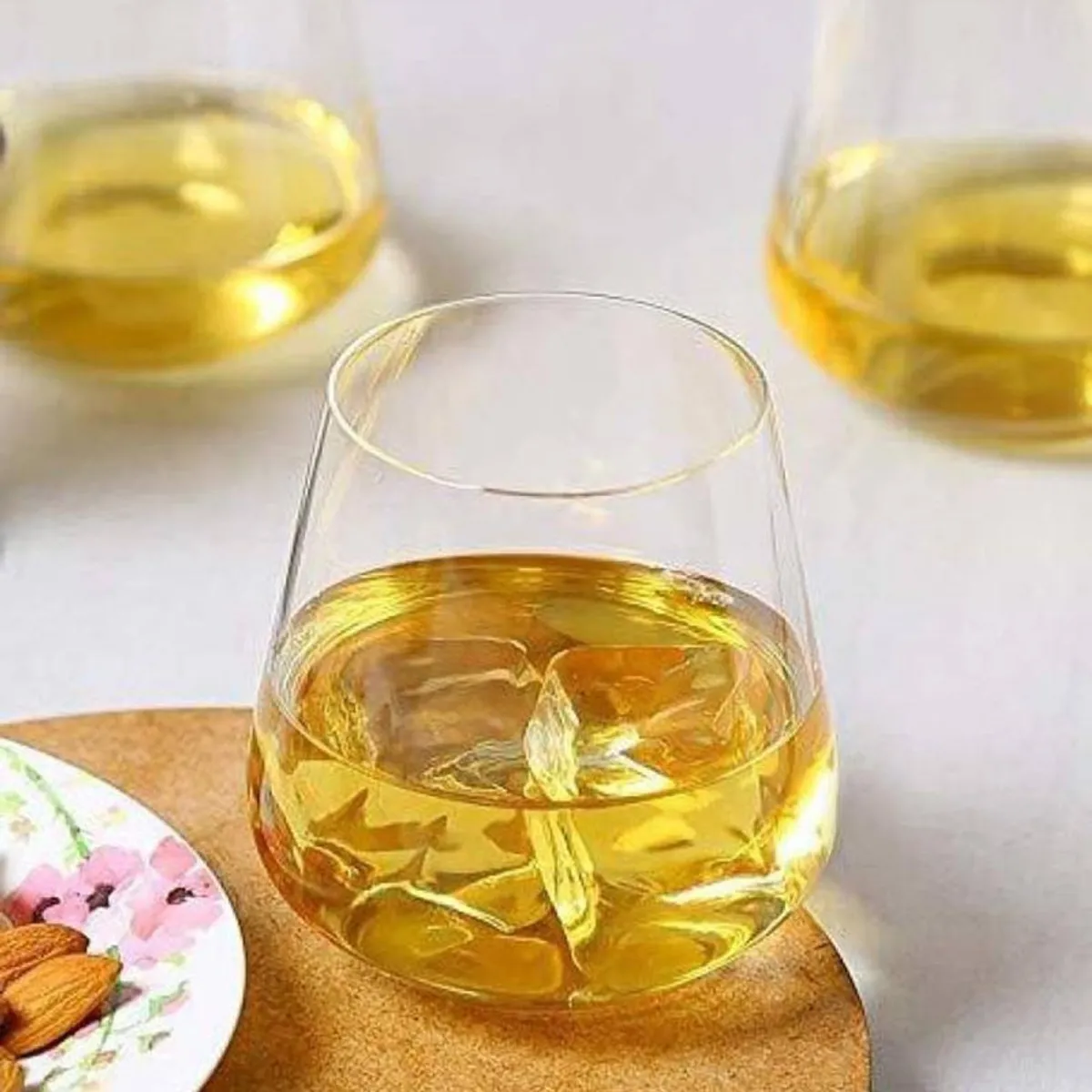 Transparent whiskey glass filled with amber drink on a table