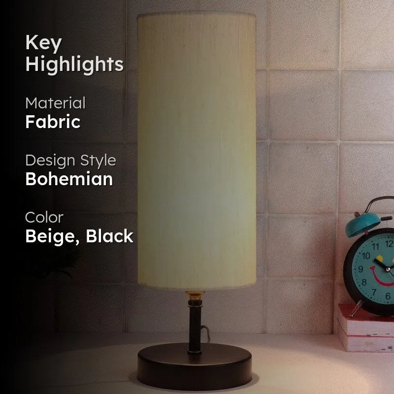 Lit beige table lamp with black base in an interior setting