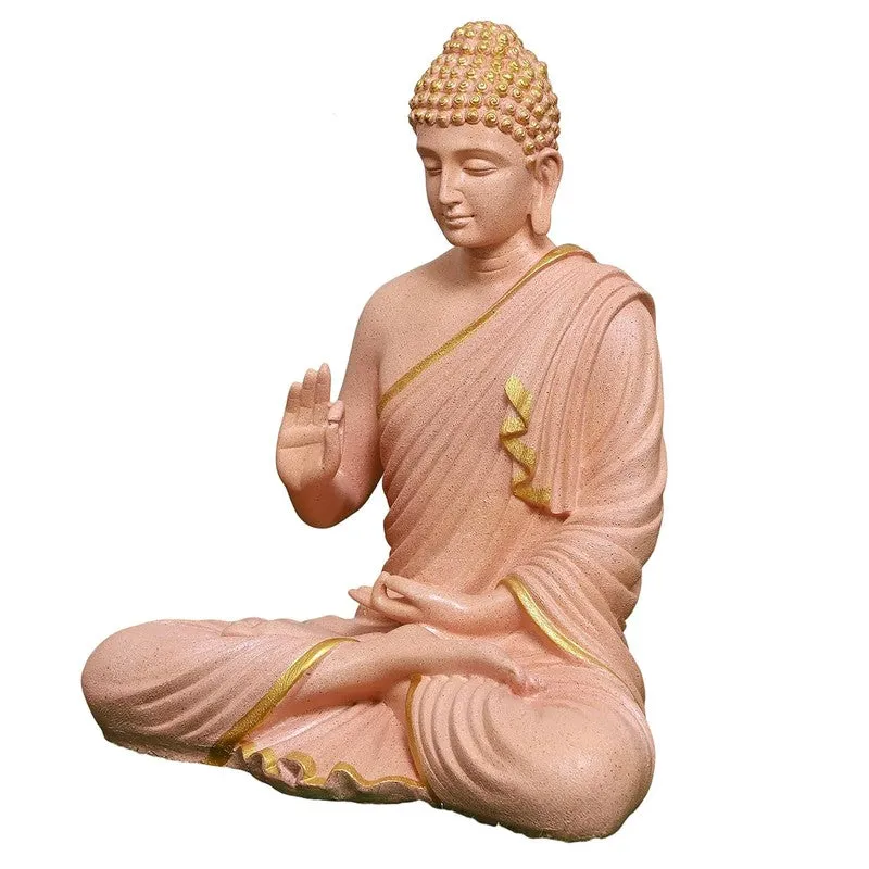 Side view of a peach Buddha idol seated in a meditative pose