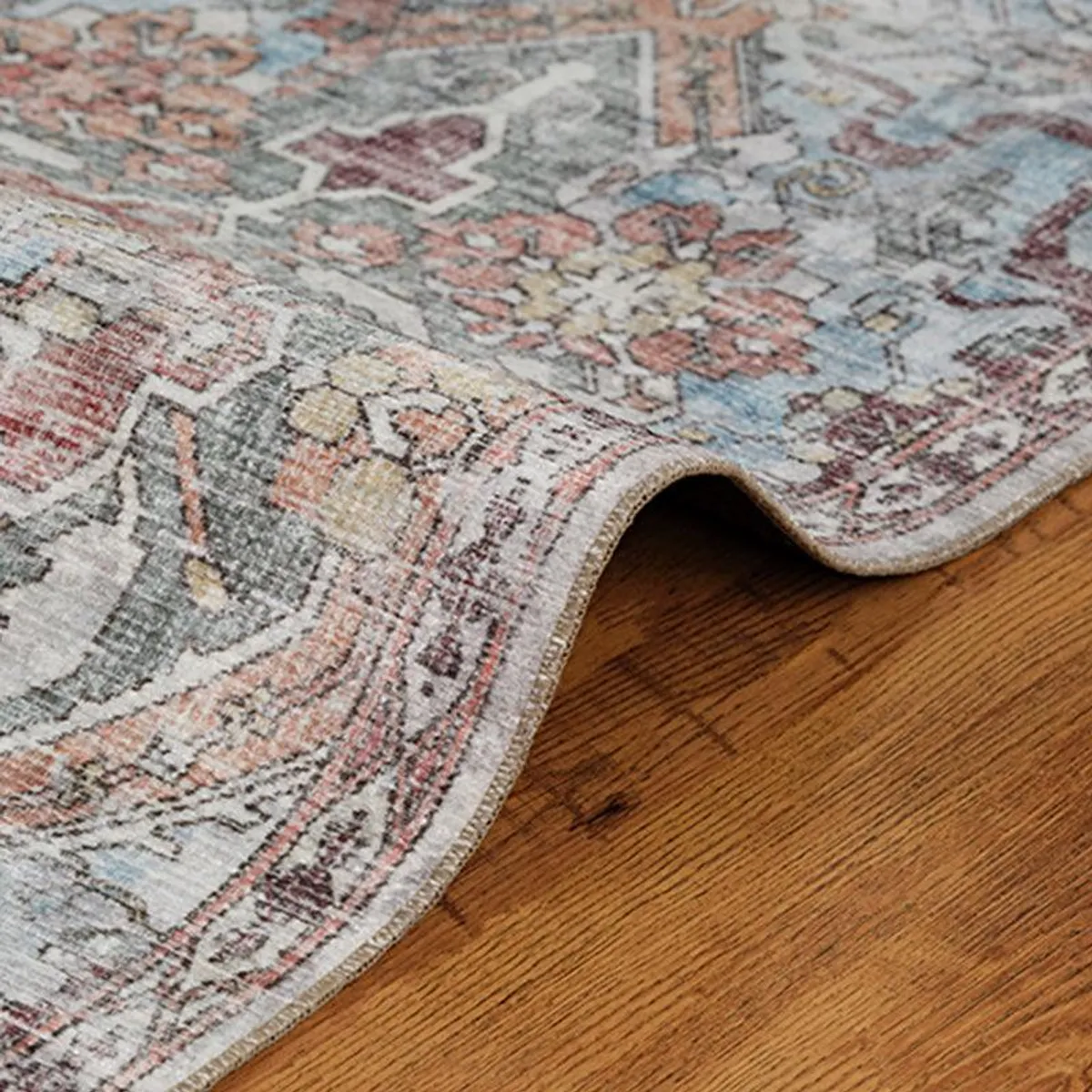 Close-up of the carpet edge showing low flat pile and multicolour ethnic pattern