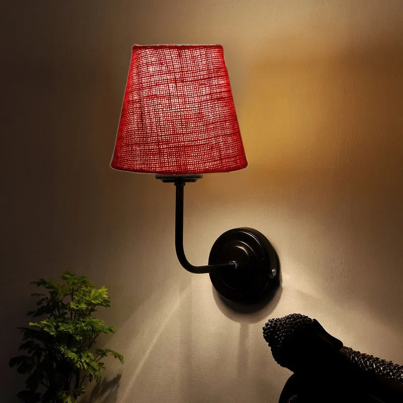 Red jute wall lamp casting warm light upward on the wall