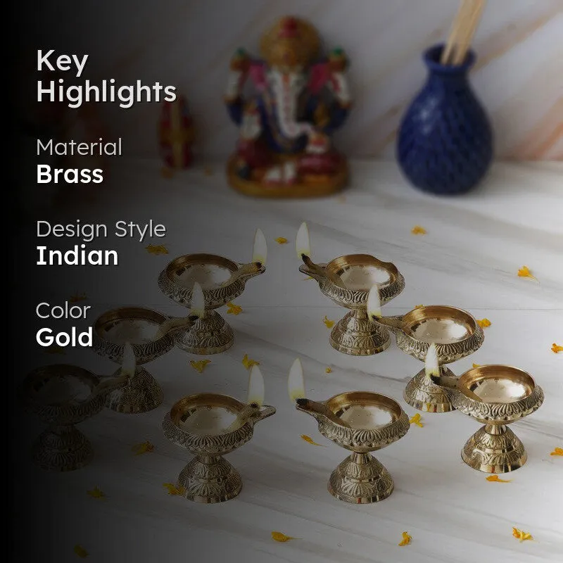 Eight gold brass diyas arranged on a white surface in a festive home setting.