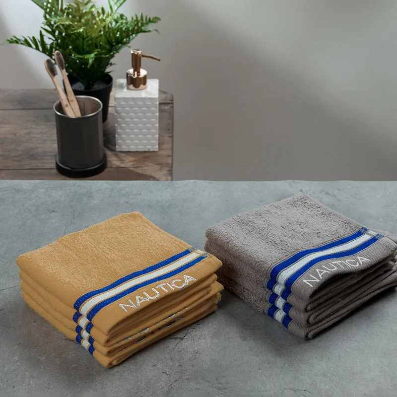 Folded grey and beige towels arranged beside bathroom accessories