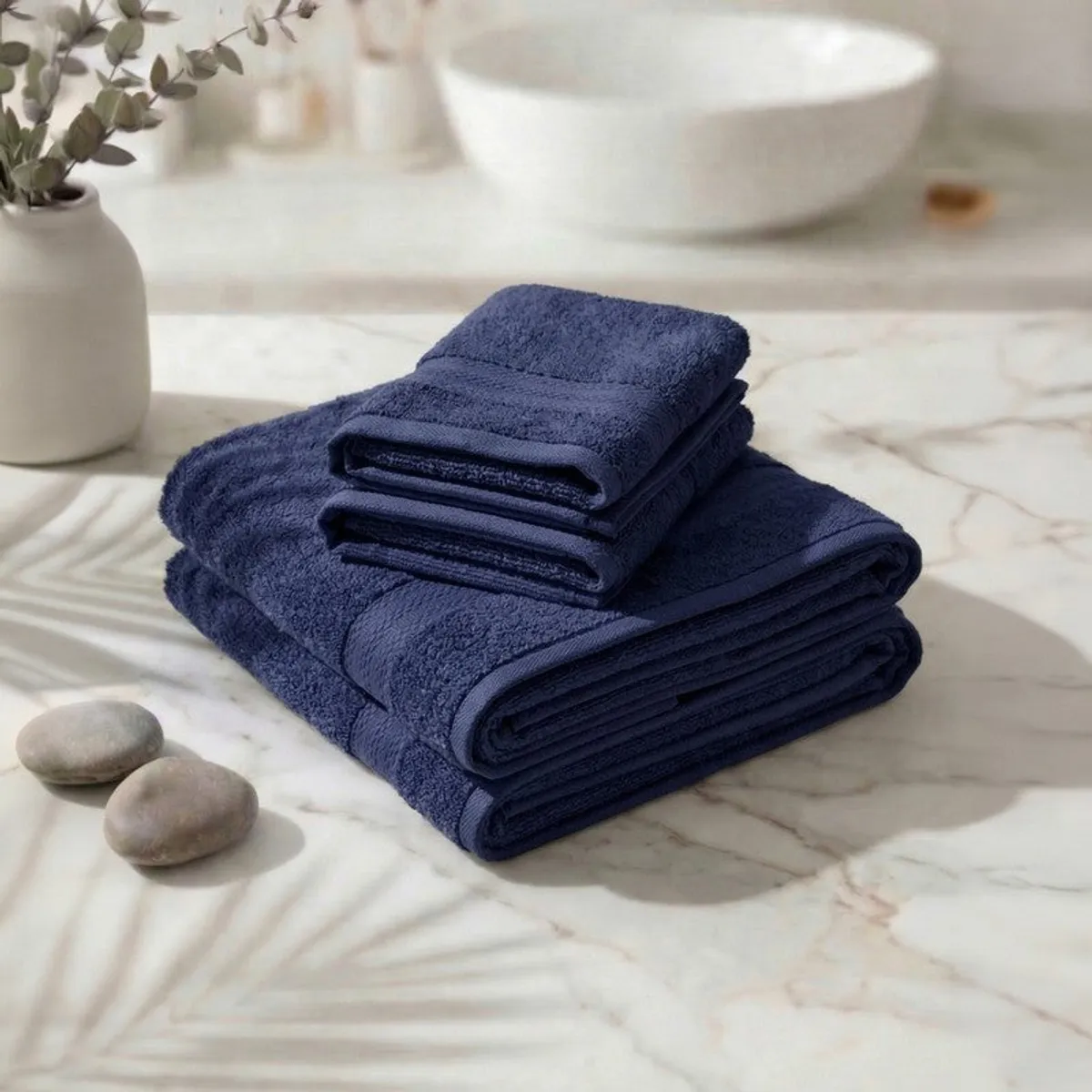 Folded blue towel set stacked on a marble surface