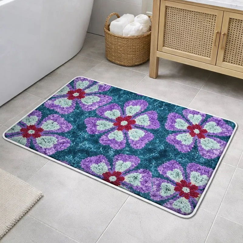 Rectangular blue and purple floral bath mat beside a bathtub and cabinet
