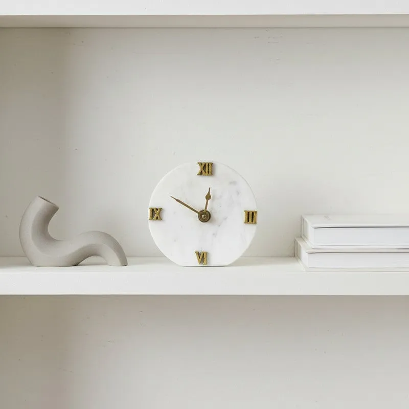 White marble table clock styled on a shelf with decor accents