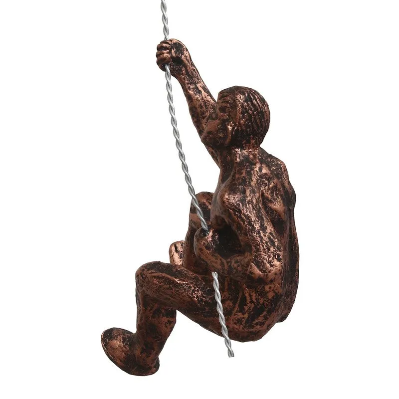 Side view of bronze-toned climbing figure wall hanging with rope detail