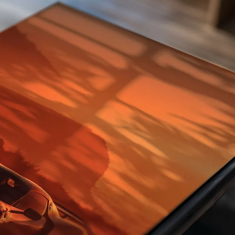 Close-up of a coastal car poster in warm orange tones