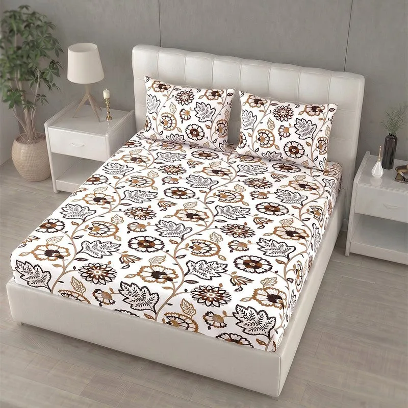 Angled view of white and brown floral bedsheet on an upholstered bed