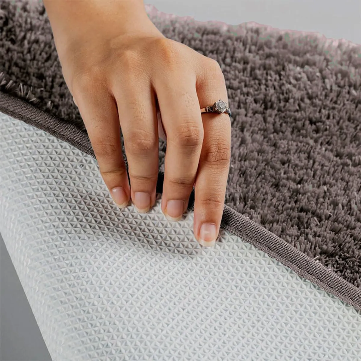 Close-up of the rug underside showing white anti-skid backing
