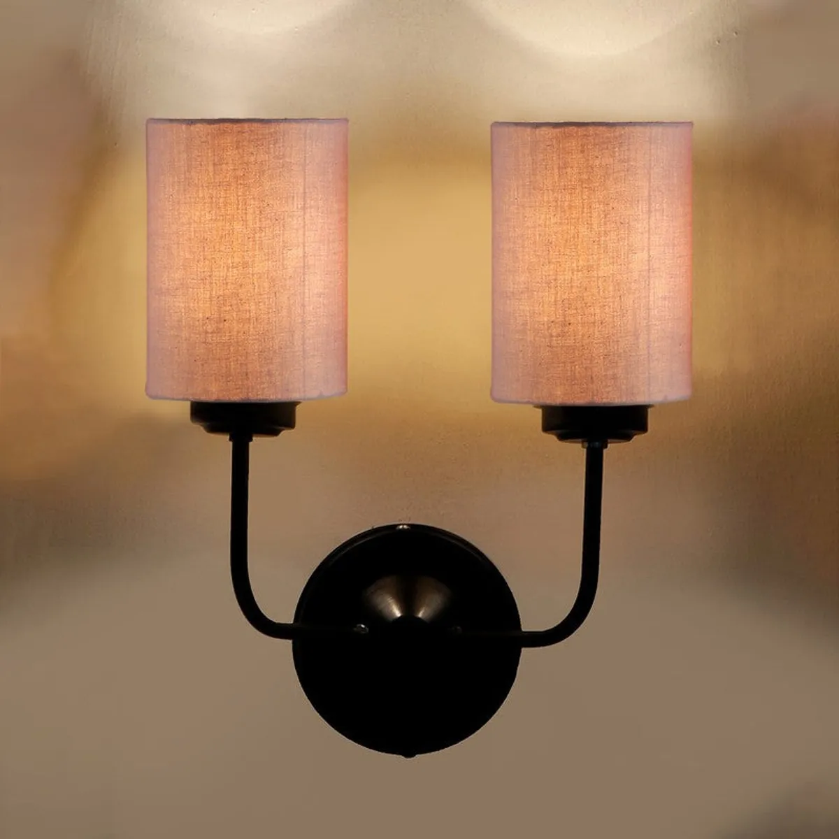Close view of illuminated beige wall lamp with black iron base