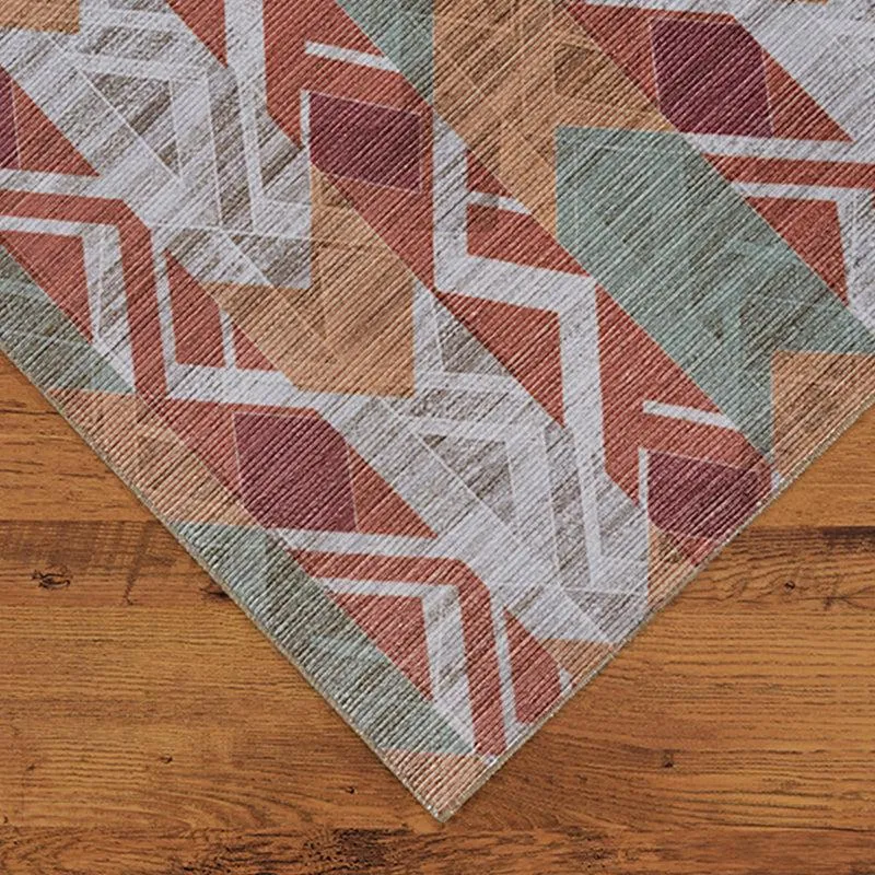 Corner view of geometric carpet in maroon, green and beige tones
