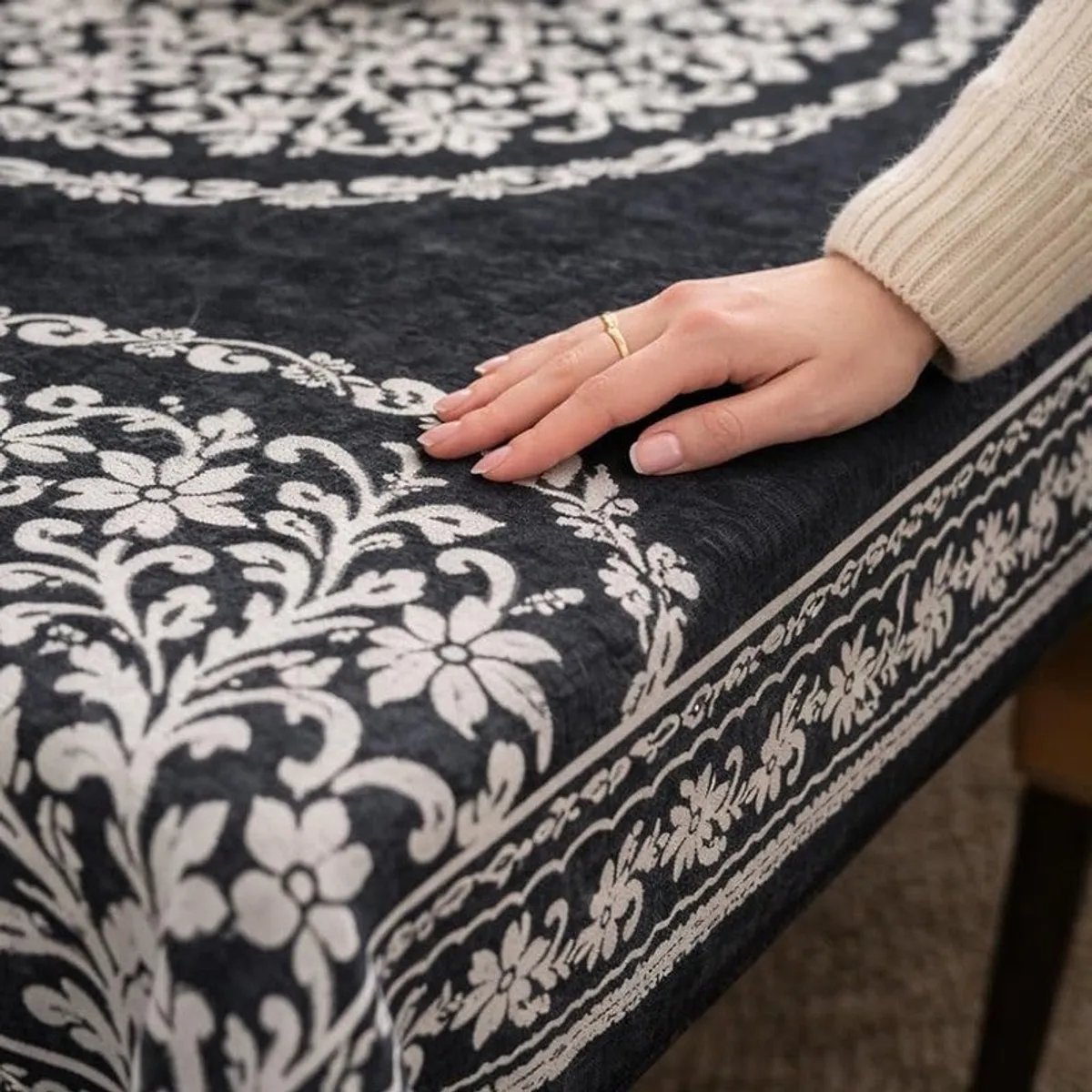 Close-up of ornate floral border and textured grey and dark blue table cover