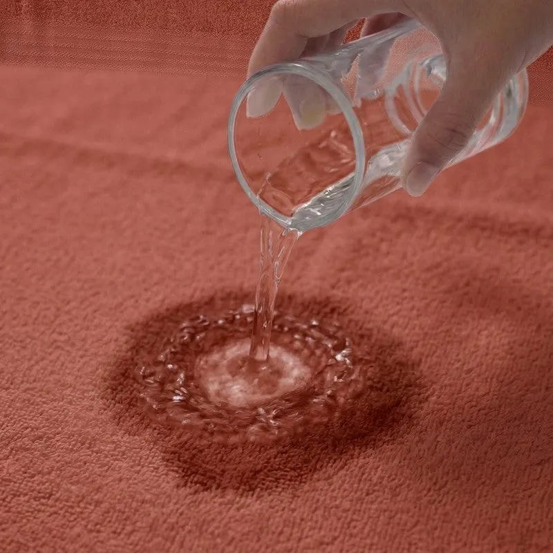 Water being poured onto a rust towel surface