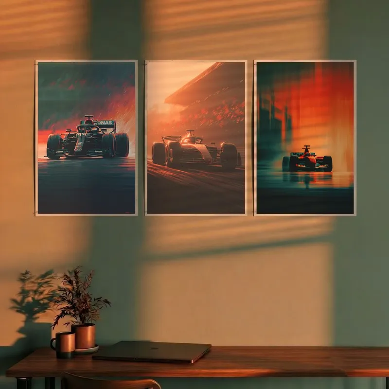 Three racing car posters displayed on a wall above a wooden desk