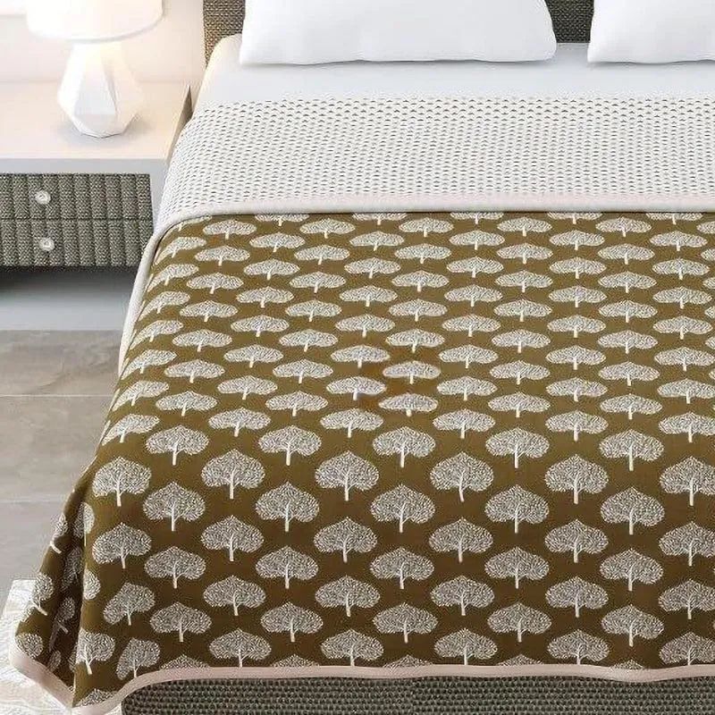Brown dohar with repeating white tree motifs spread across a bed