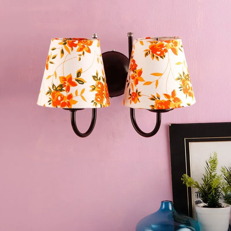 Double-shade orange and white floral wall lamp against a pink wall