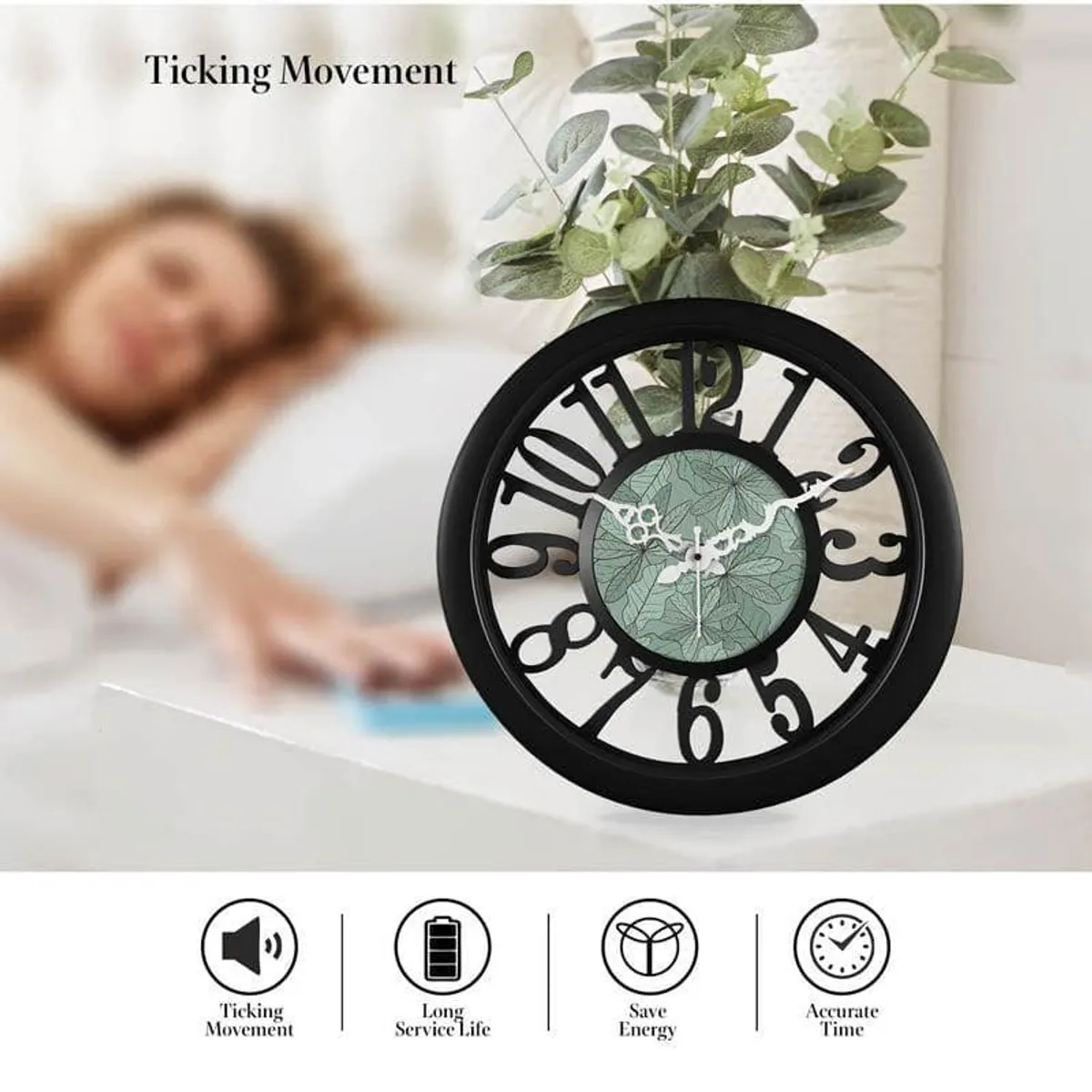 Round black wall clock with bold numerals and a leafy green centre