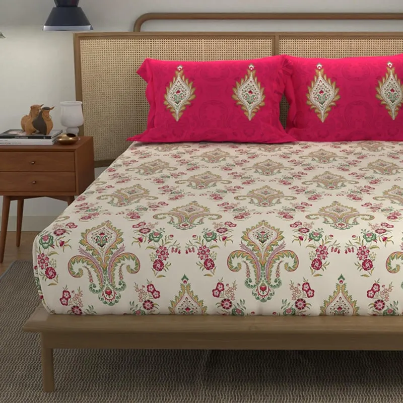 Close view of off-white bedsheet with paisley and floral motifs and pink pillow covers