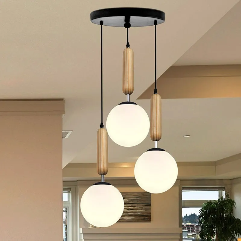 Three-light cluster ceiling lamp with round white glass shades and black canopy