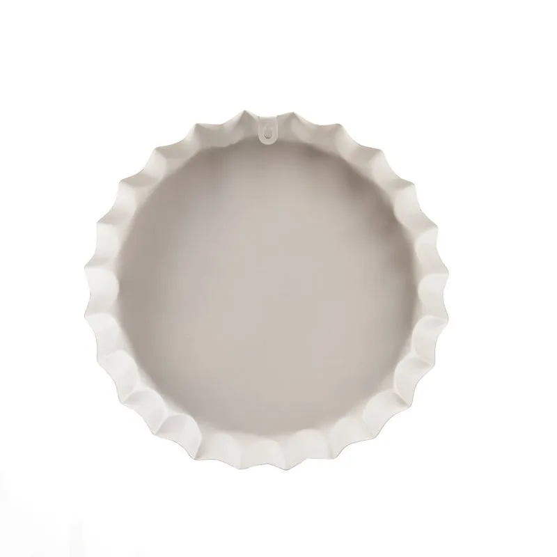 Back view of the round wall accent showing its pale metal surface and hanging point