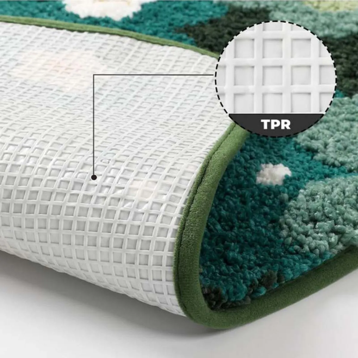 Close-up of the bath mat's white gridded anti-skid backing and green bound edge.