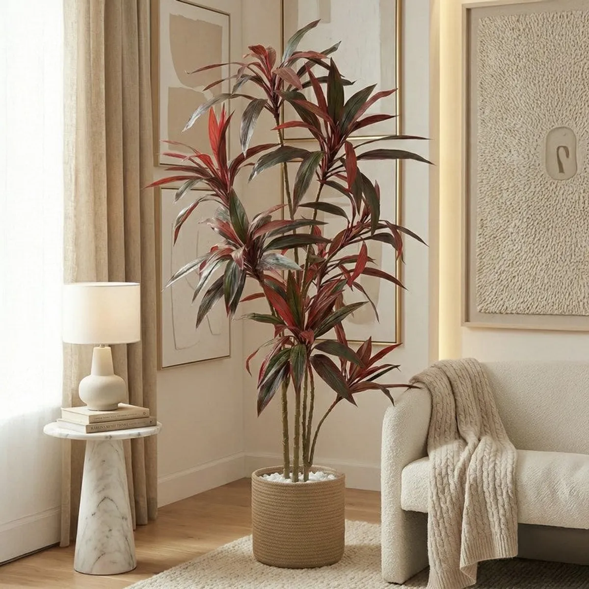 Tall red and green artificial Dracaena styled beside a neutral sofa