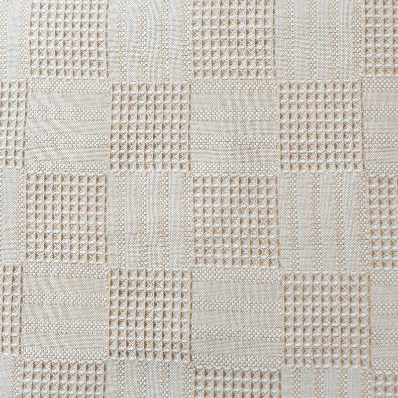 Close-up of beige textured geometric bedsheet fabric
