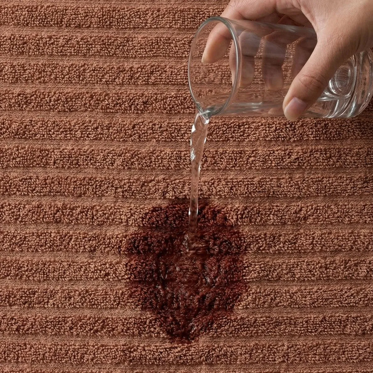 Close-up of brown textured towel surface with water poured on it