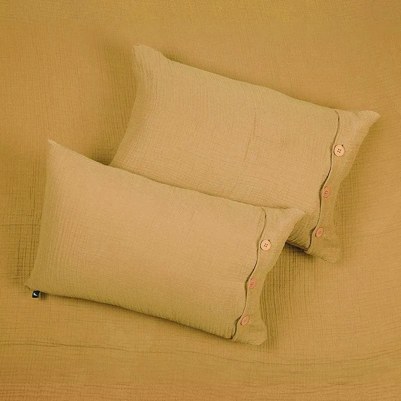 Two yellow pillow covers resting on matching textured bedding