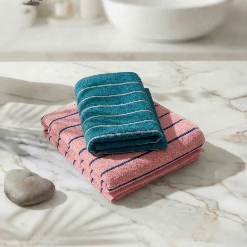 Folded blue and pink striped bath towels on a marble surface