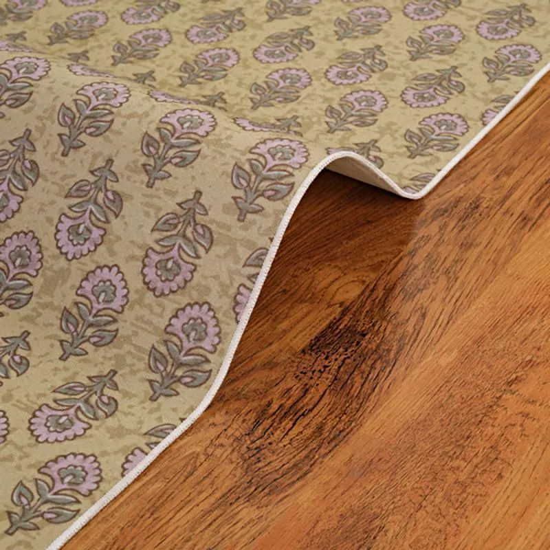 Close-up of carpet edge and floral ethnic pattern on wooden floor