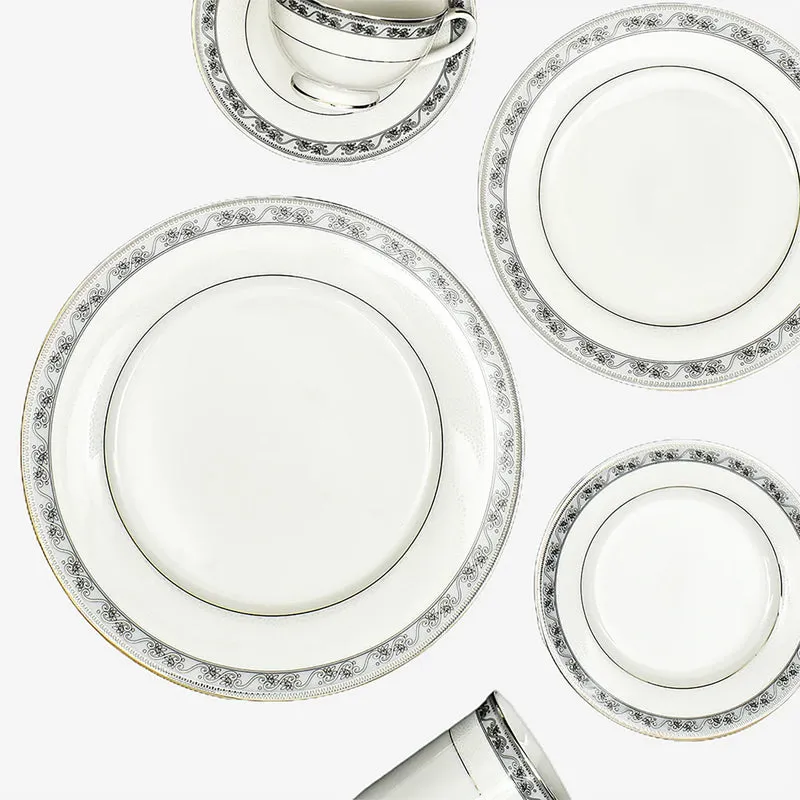 White porcelain dinnerware arranged in a flat lay with plates, bowls and a cup.