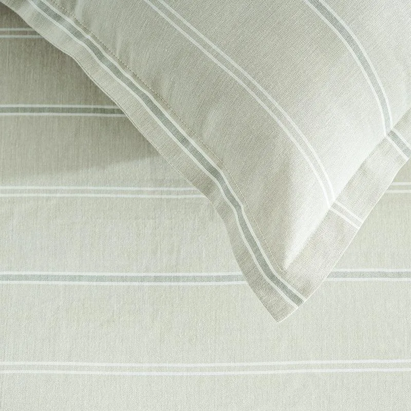 Close-up of beige bedding with subtle horizontal stripe detailing.