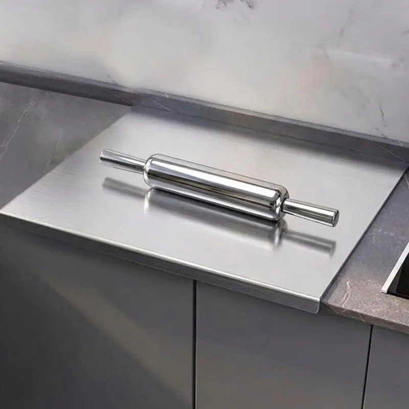 Close view of a steel rolling pin resting on a steel board