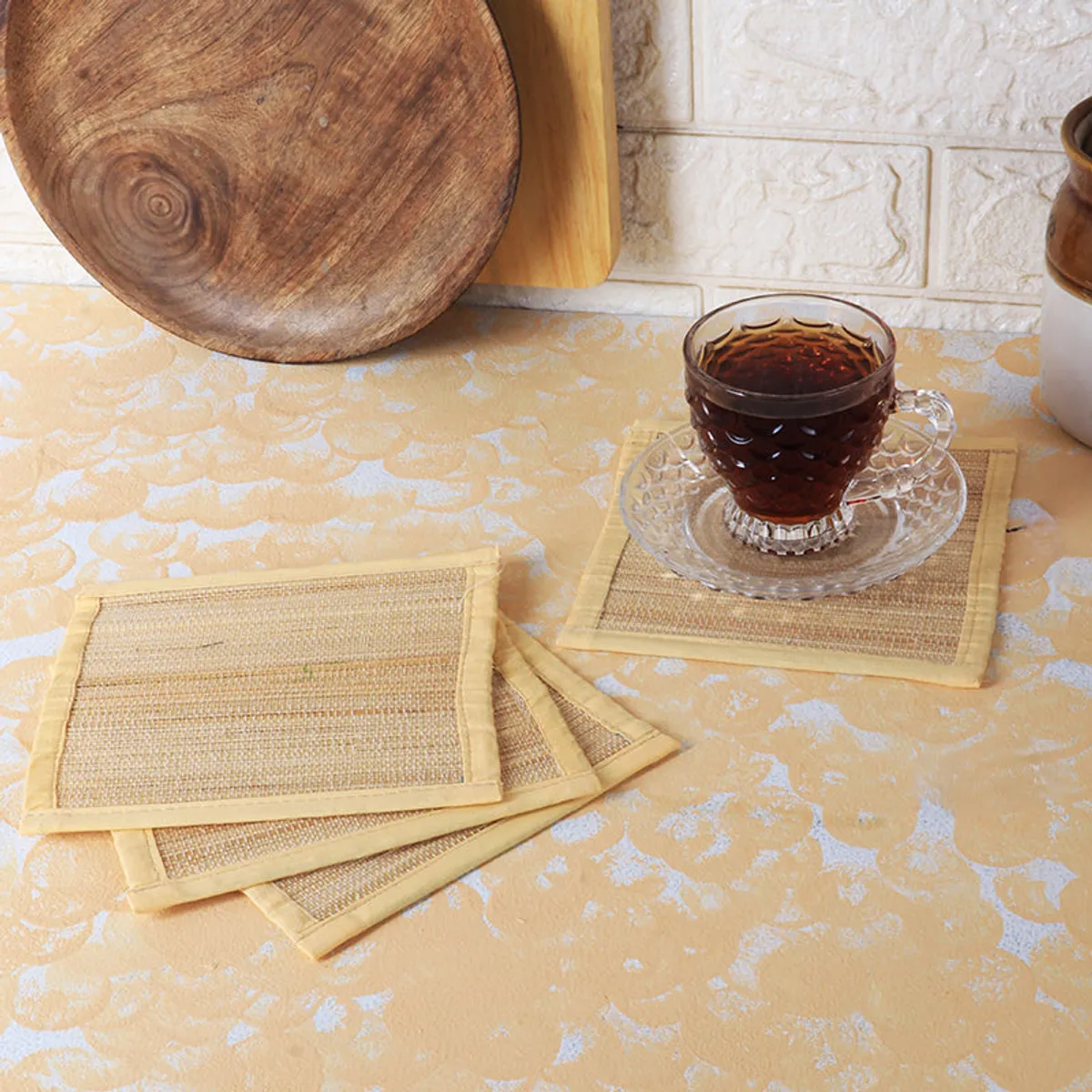 Beige square coasters styled on a table with a glass teacup